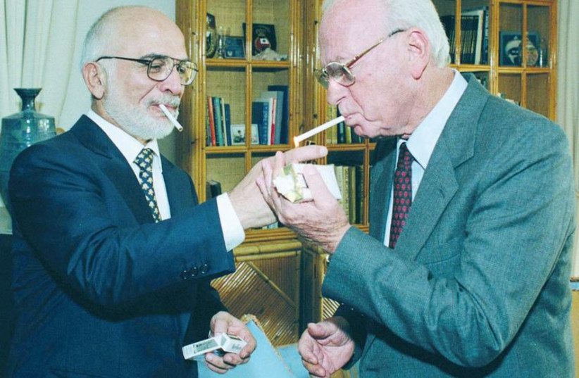 King Hussein of Jordan lights a cigarette for prime minister Yitzhak Rabin at the royal residence in Aqaba in 1994. (photo credit: GPO)