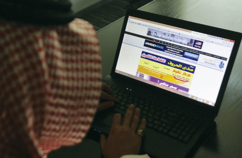 A Saudi man explores the Web on his laptop, in Riyadh in February. (photo credit: REUTERS)
