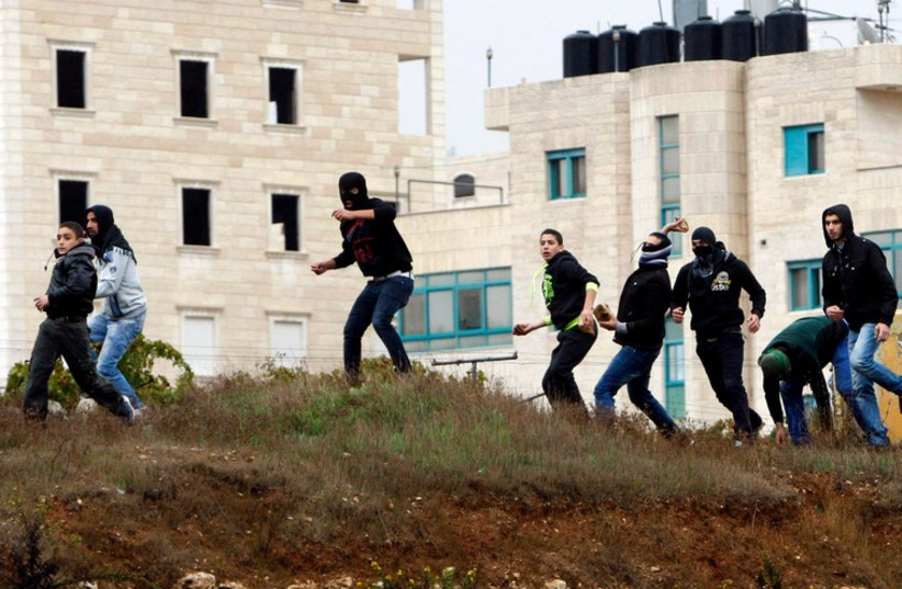 Palestinians throw stones at IDF forces during clashes in the West Bank city of Hebron October 31, 2014. (photo credit: REUTERS)