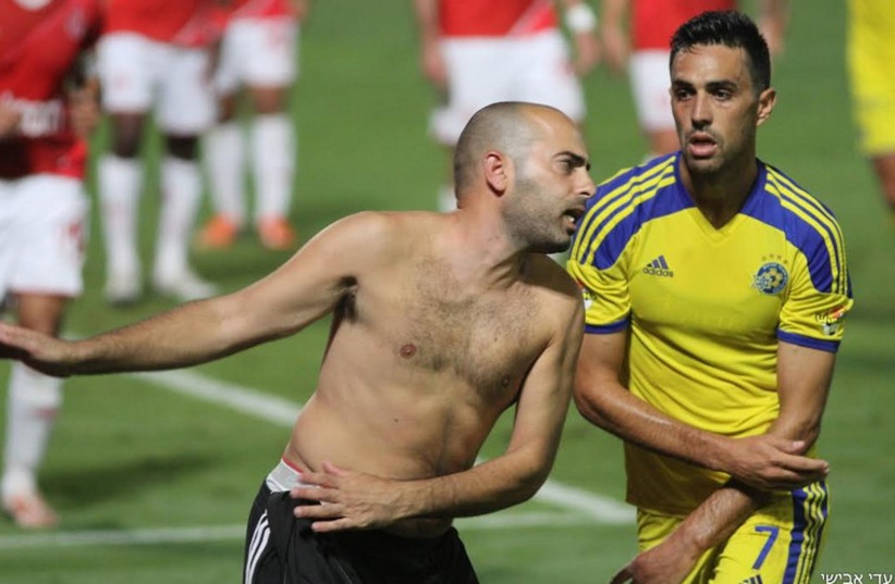 A shirtless fan takes a swing at Maccabi Tel Aviv's Eran Zahavi (photo credit: ADI AVISHAI)