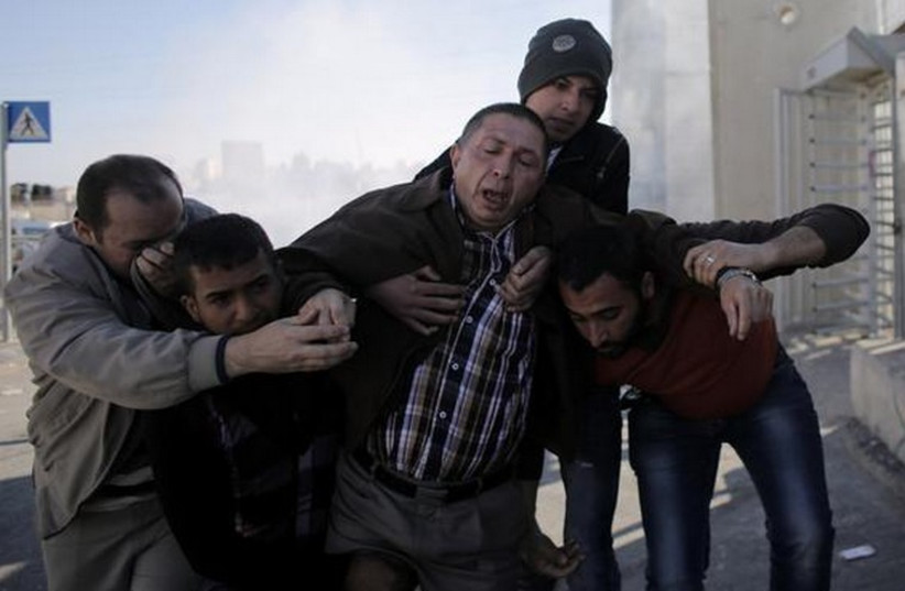 Palestinians react to tear gas fired at rioters in Jerusalem (photo credit: REUTERS)