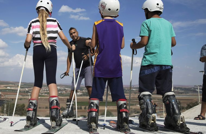 Kids receive instructions on how to ski at an artificial ski slope near Afula in the Jezreel Valley, October 15 (photo credit: FINBARR O'REILLY / REUTERS)