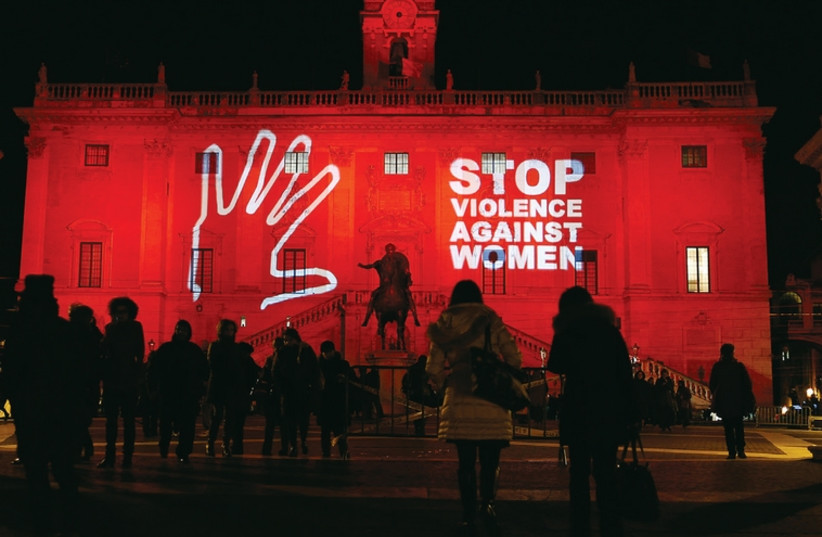 People look at a message projected at Rome’s Campidoglio palace, as part of International Day to End Violence Against Women, on November 25, 2013. (photo credit: REUTERS)