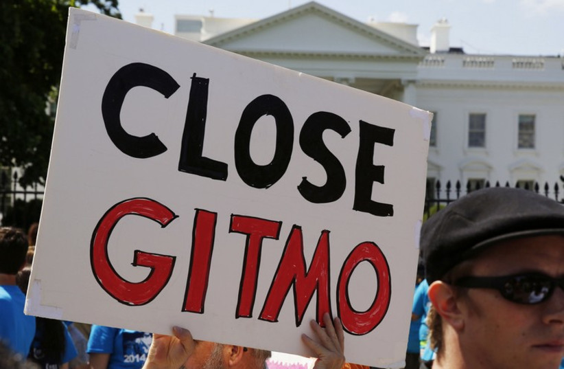 An activist holds a sign at a rally next to the White House calling for the closure of the US-run Guantanamo Bay prison in Cuba (photo credit: REUTERS)