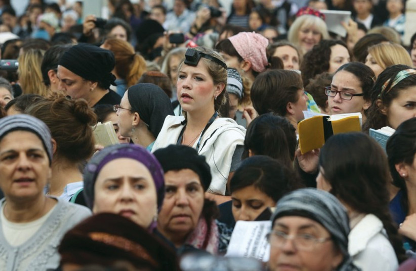 A woman wears tefillin while praying at the Western Wall (photo credit: MARC ISRAEL SELLEM/THE JERUSALEM POST)