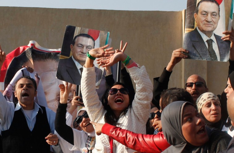 Supporters of former Egyptian President Hosni Mubarak wait for him to be transferred to a court in Cairo, November 29 (photo credit: REUTERS)