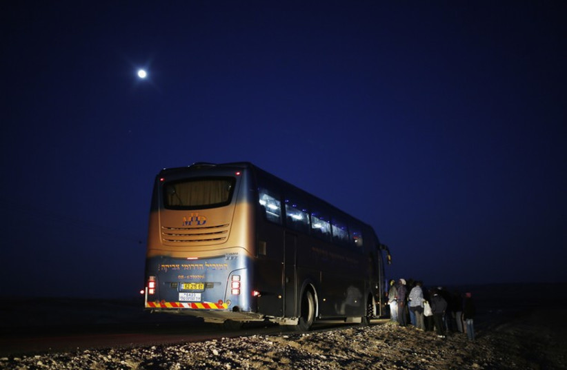 African migrants stand next to a bus after abandoning a detention facility in the southern Israeli desert (photo credit: REUTERS)