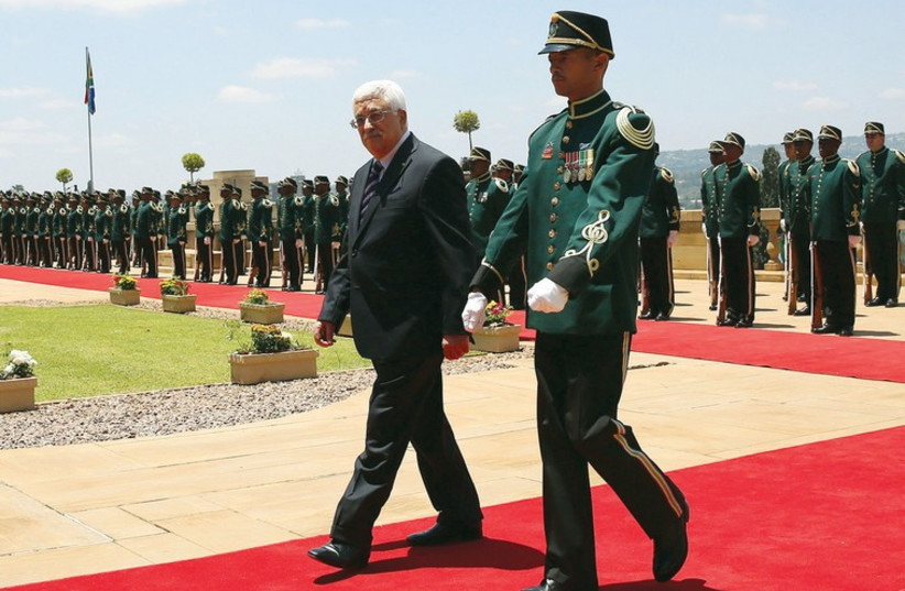 Palestinian Authority President Mahmoud Abbas walks away after inspecting an honor guard at the Union Building in Pretoria last week. (photo credit: REUTERS)