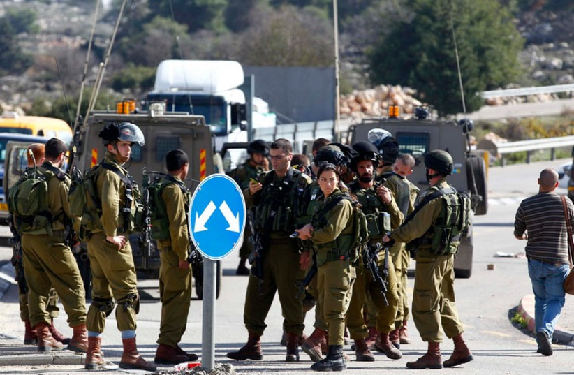 IDF soldiers at the scene of a stabbing attack in Gush Etzion, December 1, 2013. (photo credit: REUTERS)