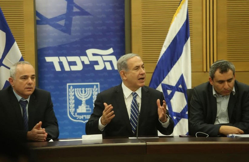 Prime Minister Benjamin Netanyahu, flanked by Likud MKs Yuval Steinitz and Ze’ev Elkin, speaks at the Likud faction meeting December 8 (photo credit: MARC ISRAEL SELLEM)