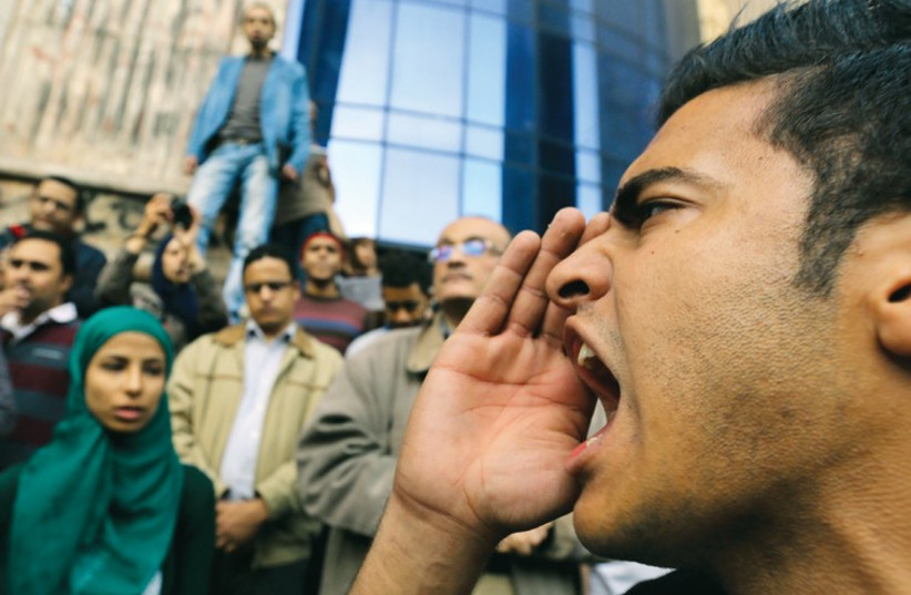 A man shouts anti-government slogans during a protest against the court dropping its case against Egypt’s former president Hosni Mubarak, in Cairo. (photo credit: REUTERS)