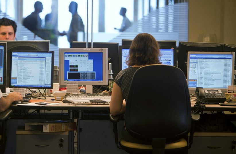 Brokers in the trading room of an investment bank in Tel Aviv (photo credit: NIR ELIAS / REUTERS)
