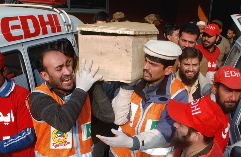 Rescue workers and family members carry the coffin of a student, who killed during an attack by Taliban gunmen on the Army Public School, in Peshawar. (photo credit: REUTERS)