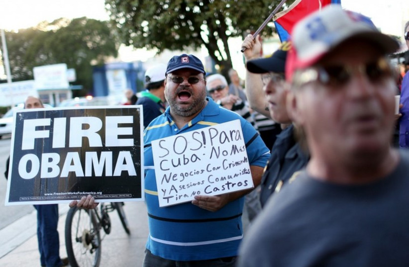 People stand outside the Little Havana restaurant Versailles, as they absorb the news that Alan Gross was released from a Cuban prison and that U.S. President Barack Obama wants to change the United States Cuba policy, Dec. 17, 2014 in Miami. (photo credit: JOE RAEDLE/GETTY IMAGES)
