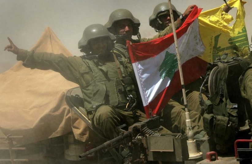 An Israeli armored personnel carrier team shows a Hezbollah and Lebanese flag as they return from fighting near the Israeli village of Avivim, July 25, 2006 (photo credit: REUTERS)
