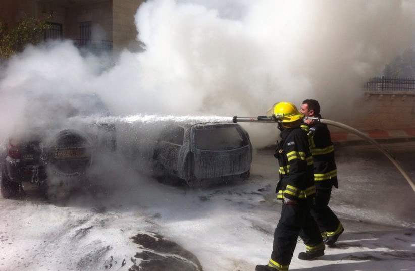 Jerusalem firefighters extinguish a car set on fire in front of the capital’s British Consulate (photo credit: JERUSALEM FIRE DEPARTMENT)