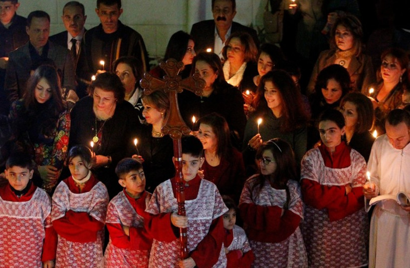 Iraqi Christians pray during a mass on Christmas eve at a church in Baghdad (photo credit: REUTERS)