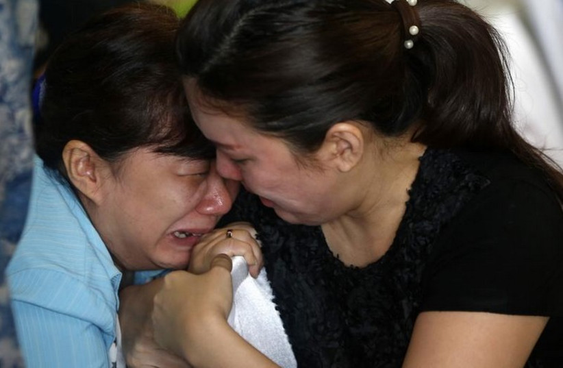Family members of passengers onboard missing AirAsia flight QZ8501 cry at a waiting area in Juanda International Airport, Surabaya (photo credit: REUTERS)