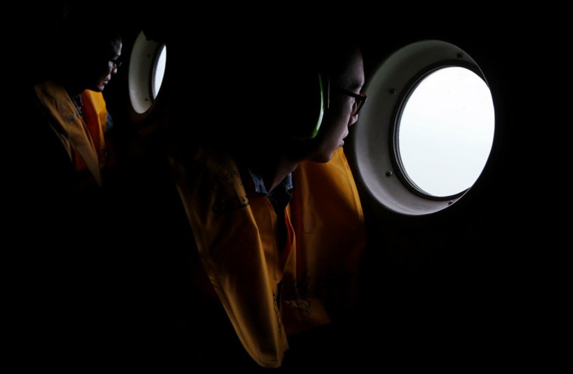 Republic of Singapore Air Force personnel survey the waters during a search and locate operation for the missing AirAsia flight QZ8501 plane December 30 (photo credit: REUTERS)