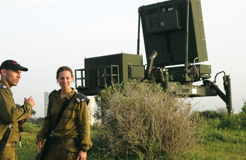 Soldiers stand near the Iron Dome missile defense system outside Tel Aviv. (photo credit: MARC ISRAEL SELLEM/THE JERUSALEM POST)