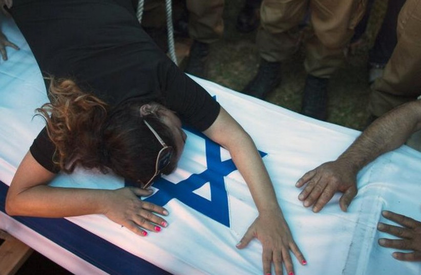 The mother of an IDF soldier killed in Gaza mourns over his coffin (photo credit: REUTERS)
