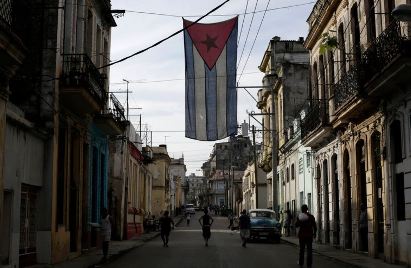 A Cuban flag hangs from a building in Havana (photo credit: REUTERS)