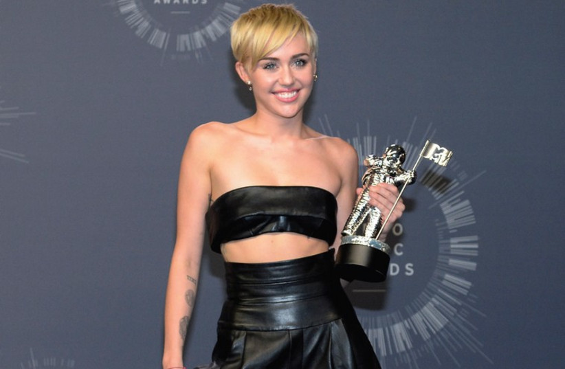 SINGER MILEY Cyrus poses backstage after winning Video of the Year for ‘Wrecking Ball’ during the 2014 MTV Video Music Awards in Inglewood, California in August. (photo credit: REUTERS)