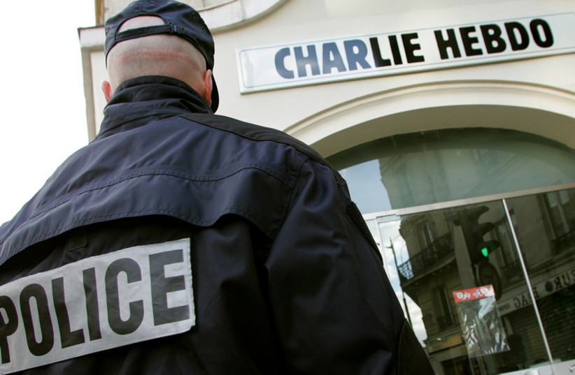 A policeman stands guard outside the French satirical weekly "Charlie Hebdo" in Paris, February 9, 2006. (photo credit: REUTERS)