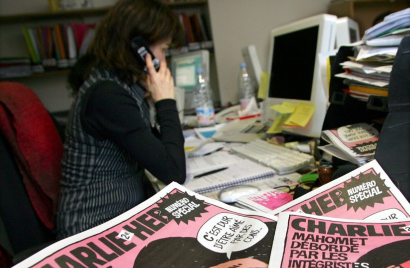 Copies of the French satirical weekly "Charlie Hebdo" are seen in its Paris newsroom (photo credit: REUTERS)