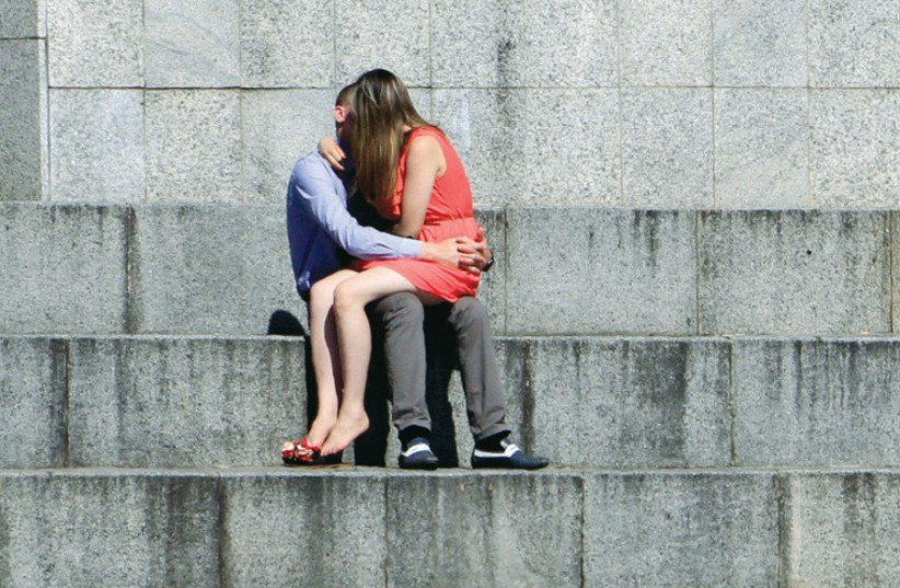 A couple share a kiss (illustrative). (photo credit: REUTERS)