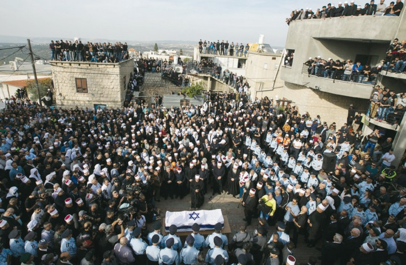 Members of the Druse community watch the funeral of Israeli Druse police officer Zidan Saif in the northern village of Yanuh-Jat on November 19, 2014. (photo credit: REUTERS)