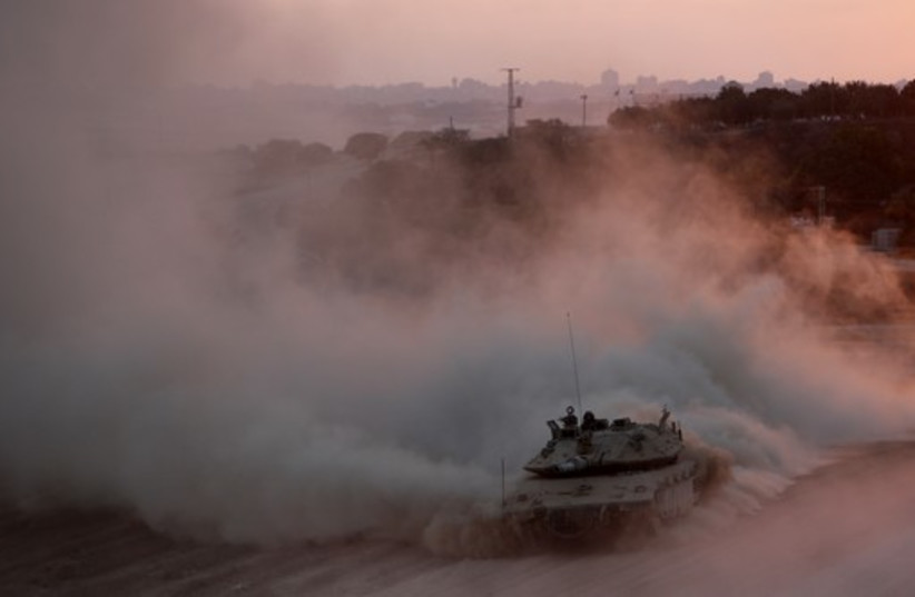 An Israeli tank drives as it returns to Israel from the Gaza Strip August 3, 2014 (photo credit: REUTERS)