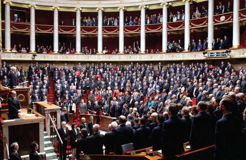 French officials observe a minute of silence during a session at the National Assembly in Paris in honor of the victims of last week’s attacks (photo credit: REUTERS)