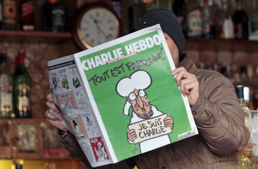 Un homme pose avec le nouveau numéro de l'hebdomadaire satirique français Charlie Hebdo dans un café de Nice.  (crédit photo: REUTERS)