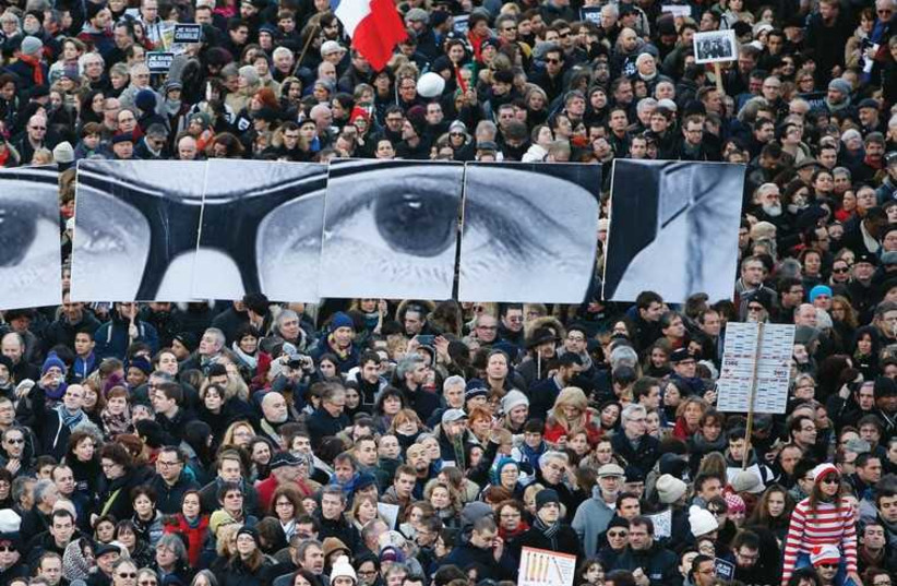 People hold panels to create the eyes of late ‘Charlie Hebdo’ editor Stephane Charbonnier. (photo credit: REUTERS)