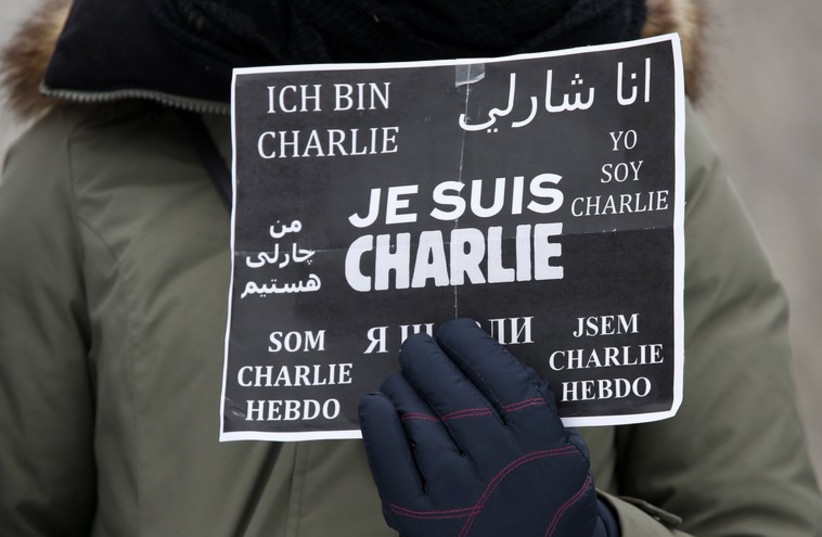 A woman holds a sign reading "I am Charlie" during a tribute for the victims of the Paris shootings, in Ottawa. (photo credit: REUTERS)