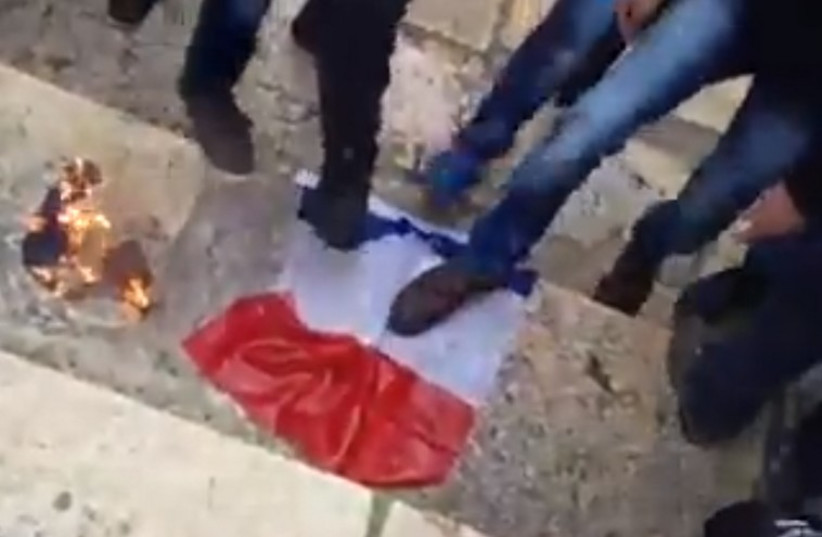 Protesters on Temple Mount burn a French Flag (photo credit: SCREEN CAPTURE: SHEHAB NEWS AGENCY/FACEBOOK)