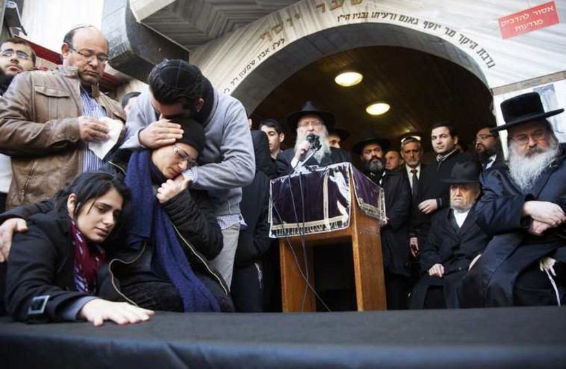 Family of victim of attack on a Paris grocery mourn beside a symbolic coffin during a procession near Tel Aviv. (photo credit: REUTERS)
