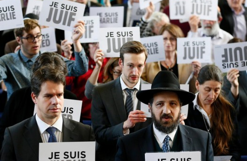 Members of the Board of Deputies of British Jews hold up signs reading "I am Charlie," "I am Jewish" and "I am Ahmed," during an event in London (photo credit: REUTERS)