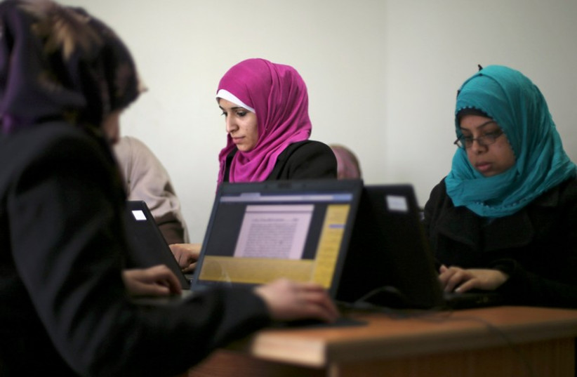 Palestinian employees process data on their laptops at Unit One in Gaza City January 15 (photo credit: REUTERS)