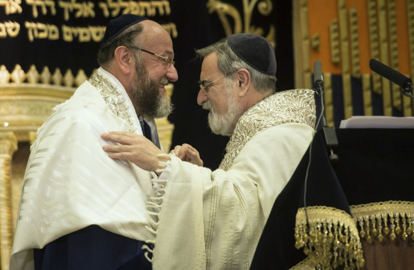 Former chief rabbi, Jonathan Sacks (R), congratulates the new chief rabbi, Ephraim Mirvis, during a ceremony at St John's Wood Synagogue in London September 1, 2013.  (photo credit: REUTERS)