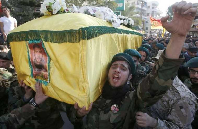 Hezbollah members react while carrying the coffin of Abbas Hijazi, who died in an airstrike in Quneitra (photo credit: REUTERS)