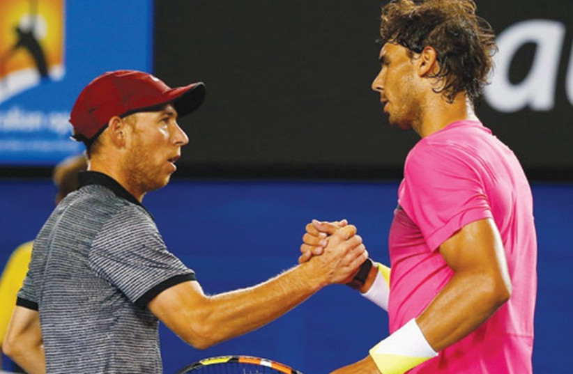 Rafael Nadal of Spain shakes hands with Dudi Sela (left) of Israel after defeating him 6-1, 6-0, 7-5 in their men’s singles third round match at the Australian Open on Friday. (photo credit: REUTERS)