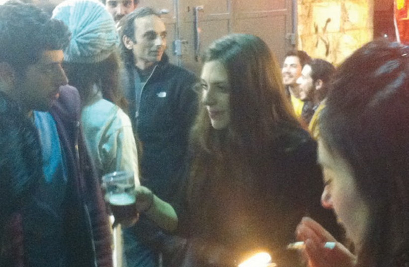 A woman smokes a cigarette while dancing at the Shuka bar in Jerusalem. (photo credit: LAURA KELLY)