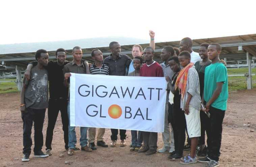 Yosef Abramowitz (center), Gigawatt Global’s president and co-founder, stands with Agahozo-Shalom Youth Village students at the opening of East Africa’s first solar field on Wednesday (photo credit: SHARON UDASIN)