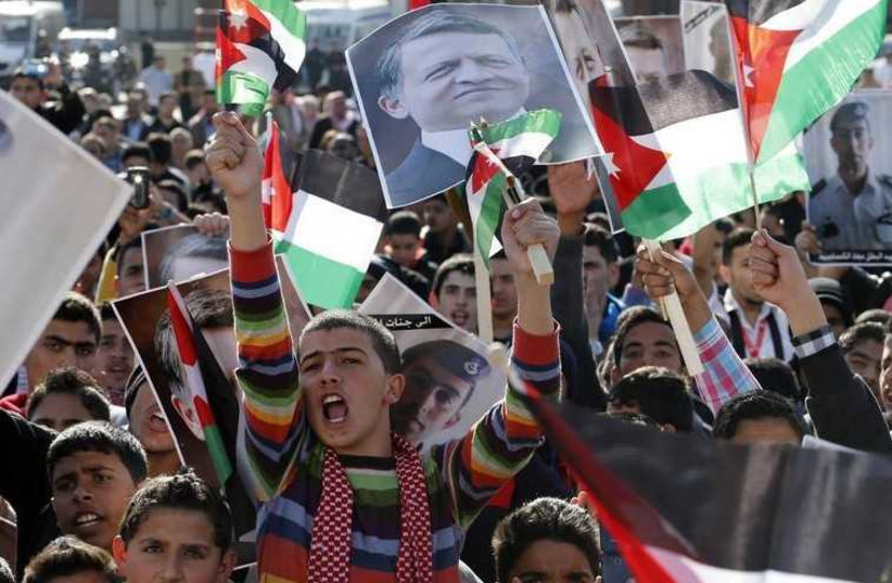 Protesters hold up pictures of Jordan's King Abdullah and pilot Muath al-Kasaesbeh