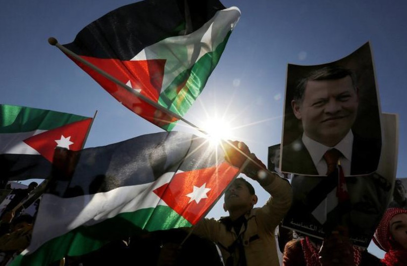 Protesters hold up pictures of Jordanian King Abdullah and pilot Muath al-Kasaesbeh