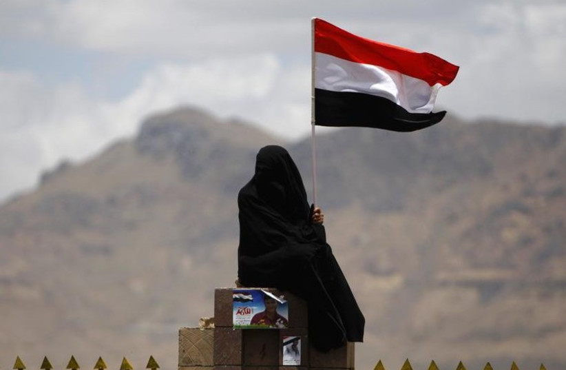 A woman holds the Yemenite national flag (photo credit: REUTERS)