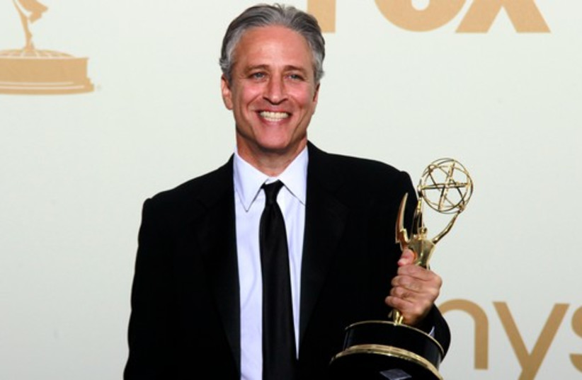 Jon Stewart holds the Emmy award for the "The Daily Show" in 2011 (photo credit: REUTERS)