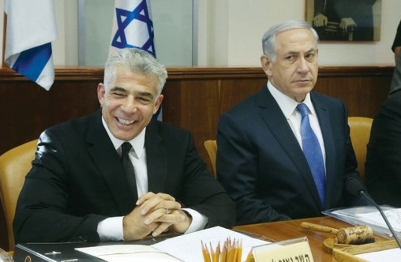 Netanyahu and Lapid at a cabinet meeting in October 2014. (photo credit: MARC ISRAEL SELLEM/THE JERUSALEM POST)